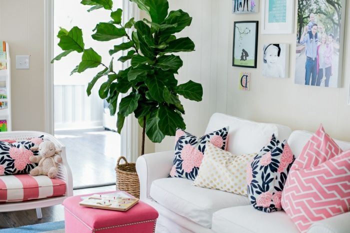 Obývacia izba s ružovými vankúšikmi s kvetinovými motívmi na bielom gauči