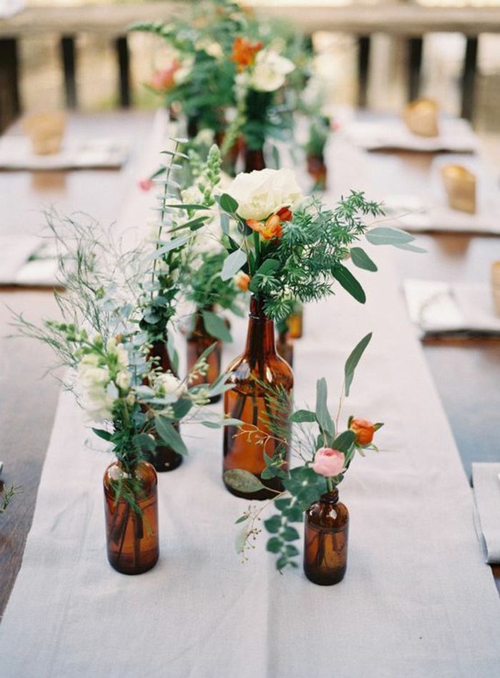 sodo stalo dekoravimas, stiklinių butelių vazos, gėlės, žalios šakos