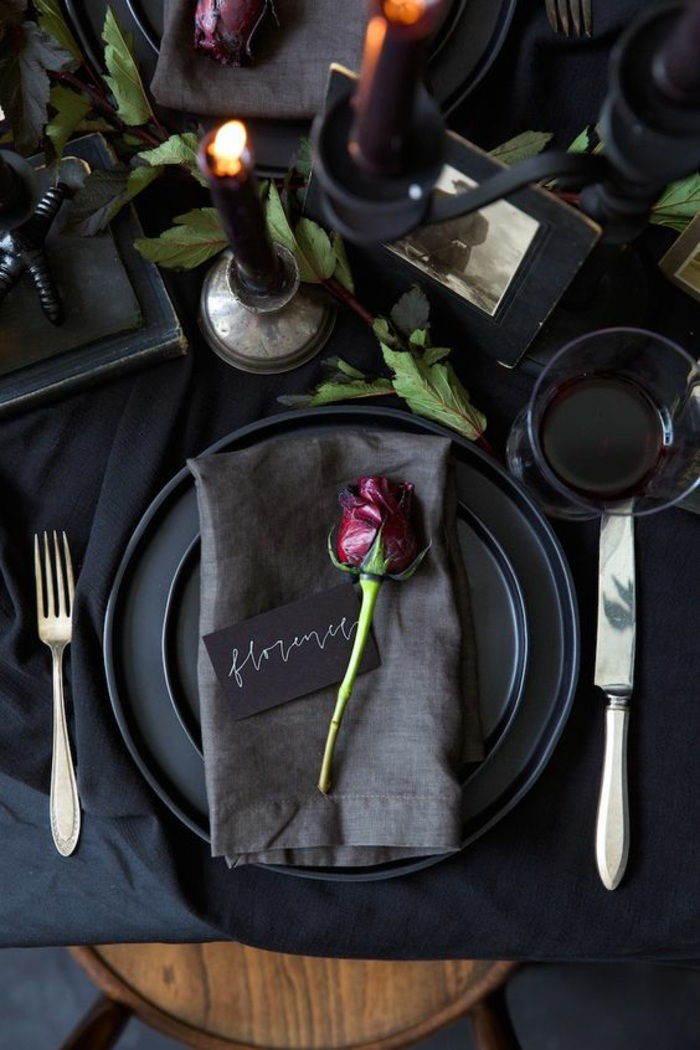 šventinė stalo apdaila juodos, pilkos servetėlės, rožės, stalo įrankiai, žvakė