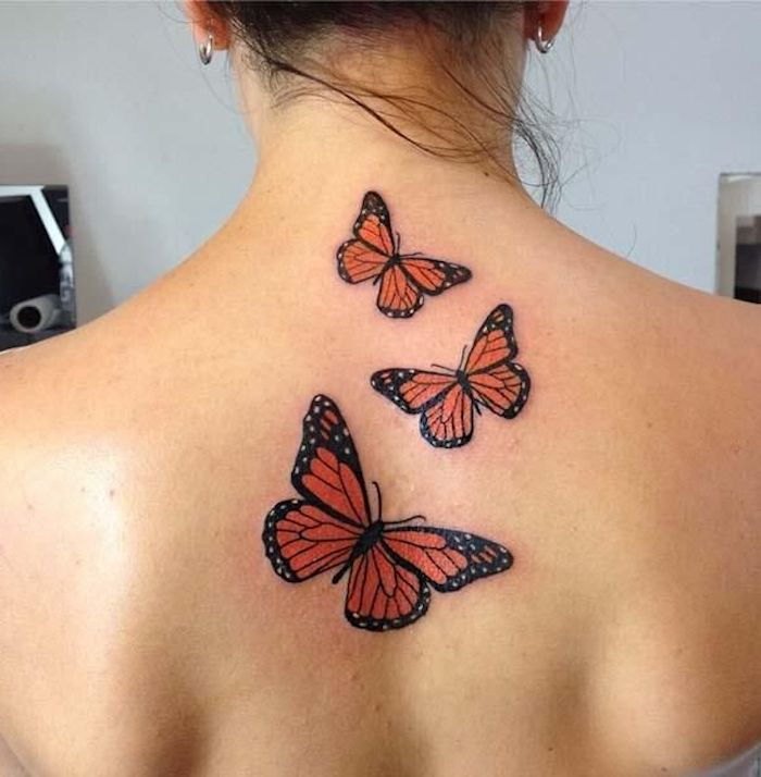 dar viena puiki 3d tatuiruotės drugelio idėja jaunos moters nugaroje - čia rasite dre plaukiojančius raudonus drugelius