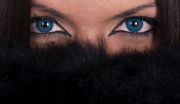Vacker kvinna med blå linser som täcker hennes ansikte