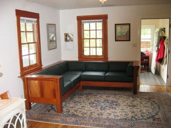 Kampinė sofa apima juodos spalvos ir medines dalis