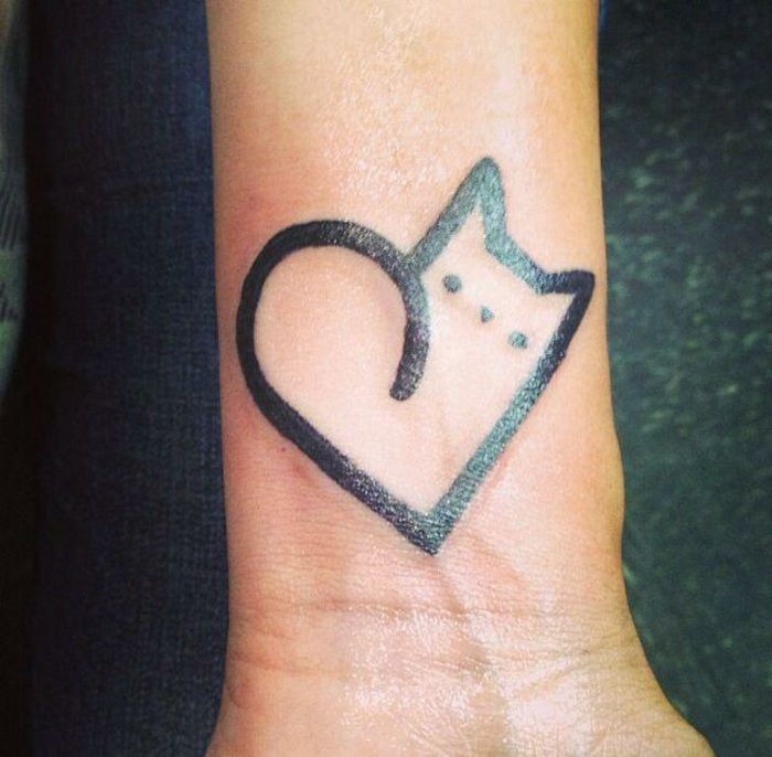 Tatuaż kota na nadgarstku - czarny kot o małych oczach i sercu