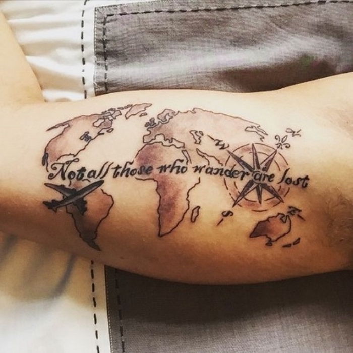 pasaulio žemėlapis, mažas juodas kompasas ir juodos antraštės - kompaktiškos tatuiruotės idėja