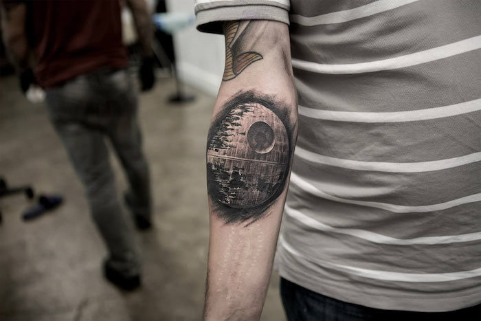 muž s tetovaním hviezdnych vojen s veľkou čiernou vesmírnou loďou - ruku s tetovaním - muž so šedým tričkom