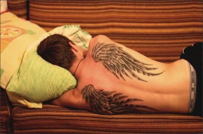 oto pomysł na tatuaż dla mężczyzn - czarne długie skrzydła anioła z czarnymi piórami