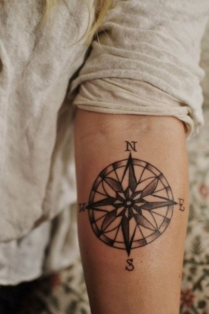 Moteris su juoda tatuiruotė su juodu kompasu - tatuiruotės idėja rankoje