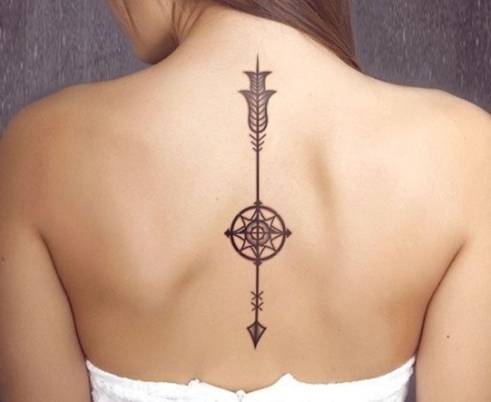 Här är en vacker ung kvinna med en svart tatueringskompass på hennes nacke - med en svart kompass