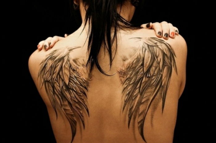žena s veľkým tetovaním anjelských krídel - tu sú dve veľké anjelské krídla s dlhým čiernym perom
