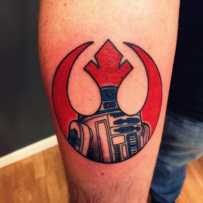 ľudia s rukou drží veľké tetovanie červené hviezdy wars s logom hviezdnych vojen s červenou loďou a malým bielym robotom