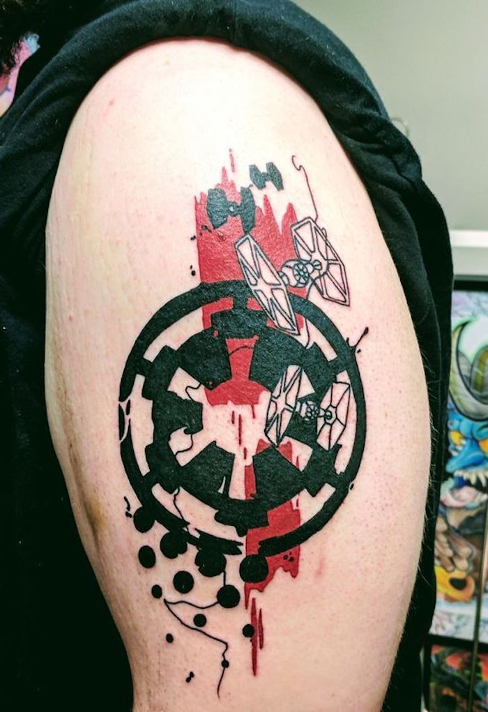 muž s ruku drží tetovanie veľkých hviezdnych vojen s logom čiernej hviezdy vojny a dvoma malými bielymi vesmírnymi loďami