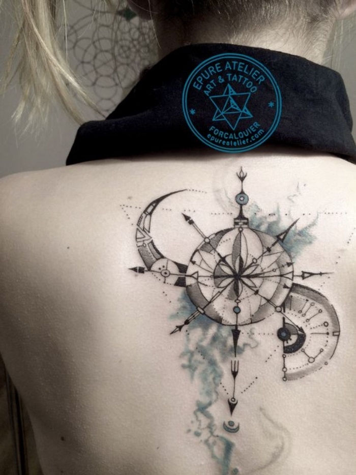 mėnulis ir juodas didelis steampunko kompasas - kompaso tatuiruotės idėja jaunos moters nugaroje
