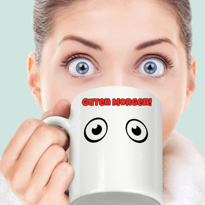 iki büyük gözü ve büyük mavi gözleri olan genç bir bayanla boyalı bir kahve kupa