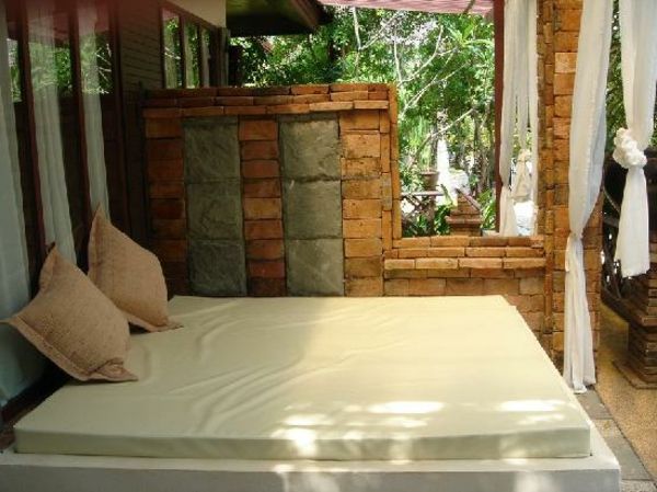 elegantné vonkajšie postele s bielymi závesmi a vankúšmi
