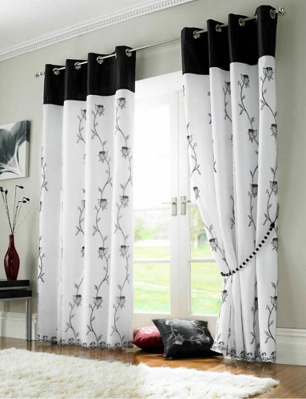 Hvite gardiner med malerier i svart, hengende fra vinduet