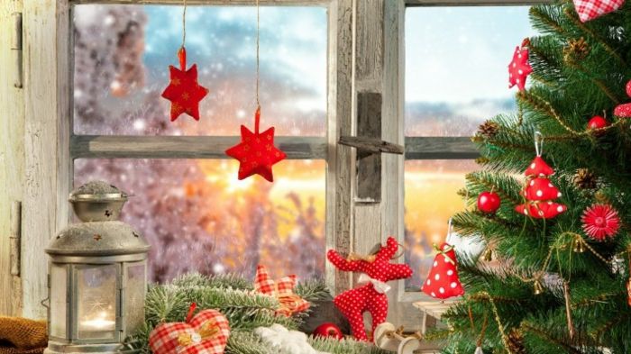 capped gran med röda juldekorationer gjorda av tyg, julgranar av rött tyg med vita prickar, gran med fairy ljus, dekorativa element i form av ett hjärta, dekorativ hjärta av rutigt tyg, Latenr med metallock, röda julstjärnor vid fönstret