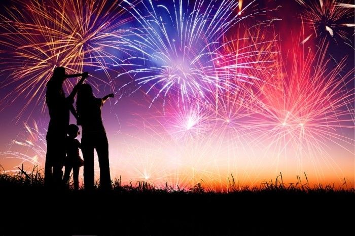 Família feliz em pé na colina e assistindo os fogos de artifício