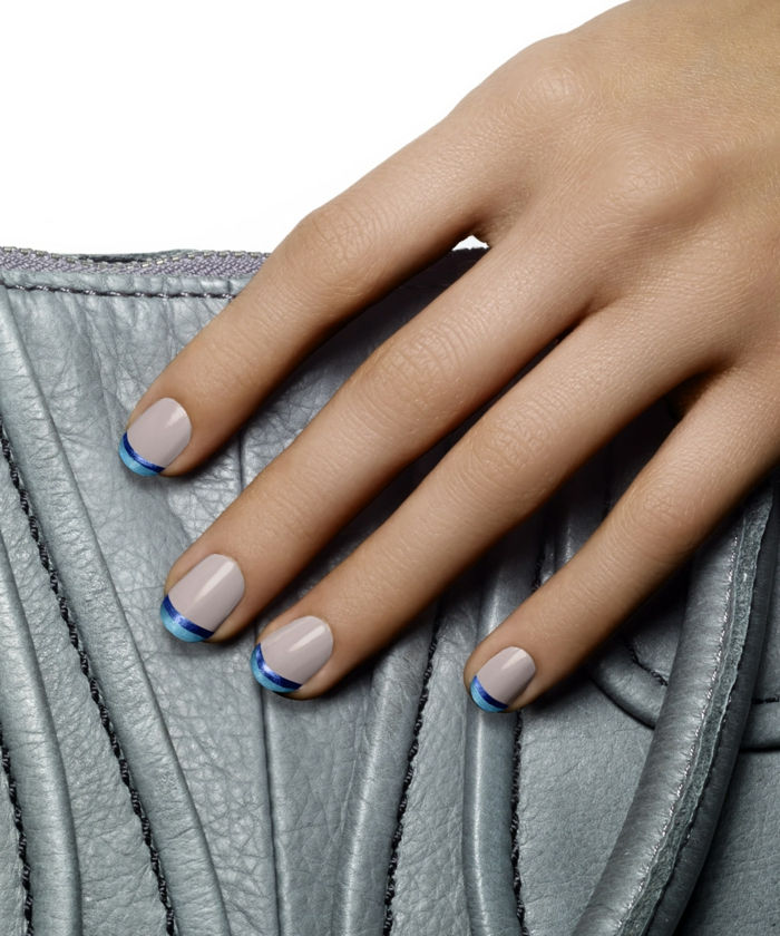 Francoska manikura modre in bele, ovalne oblike nohtov, siva usnjena torba kot ozadje