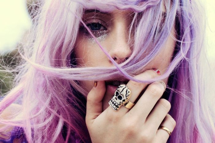 Femeie cu păr roz, cu nuanțe violete, inel mare de argint sub formă de craniu