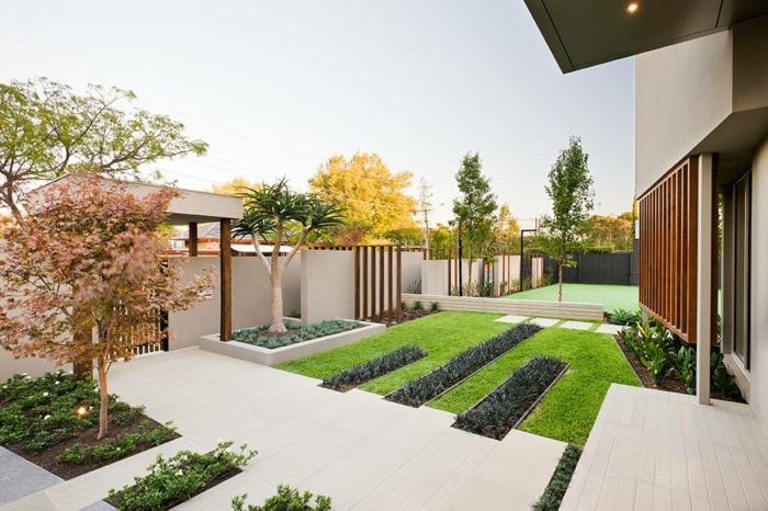 en minimalistisk trädgård bredvid ett hus i minimalistisk stil