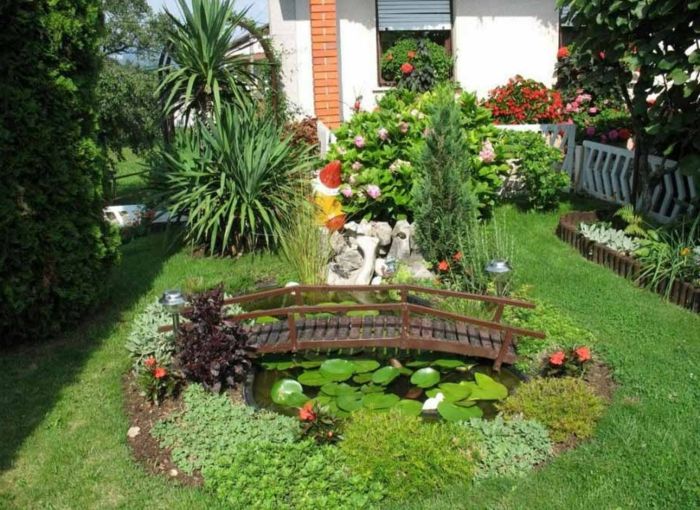 minimalistinis sodas su mažomis vandens lelijomis ir žaliu tvenkiniu su tiltu