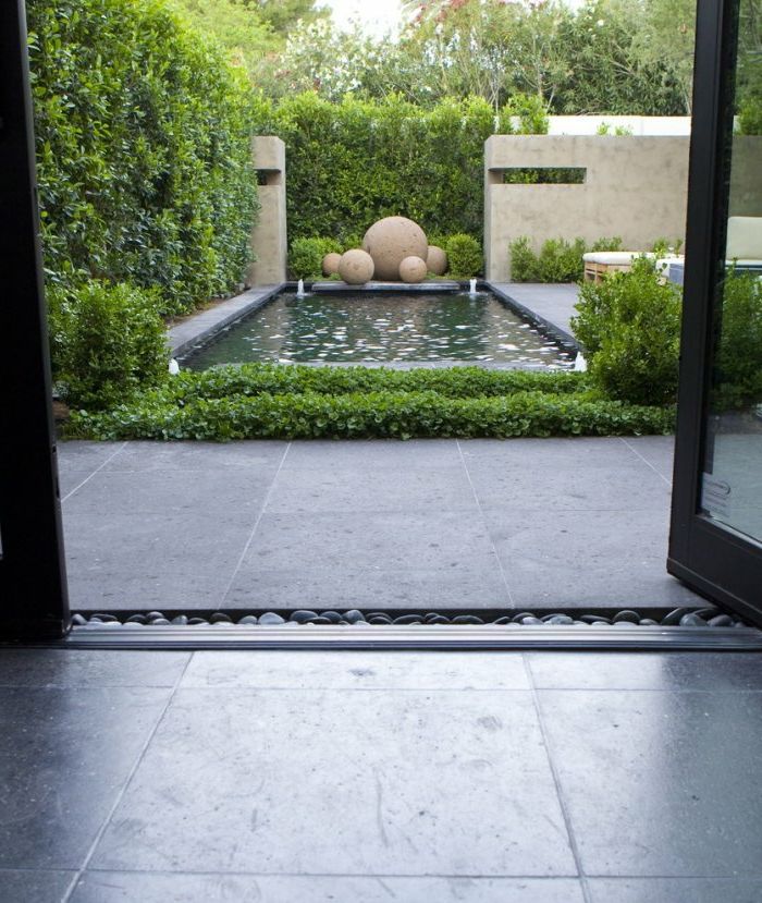 Modern trädgård design en vatten funktion med fyra fontäner i hörnen