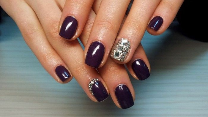 bella gel unghie decorazione di vernice viola scuro su un chiodo nel design delle unghie color argento con pietre