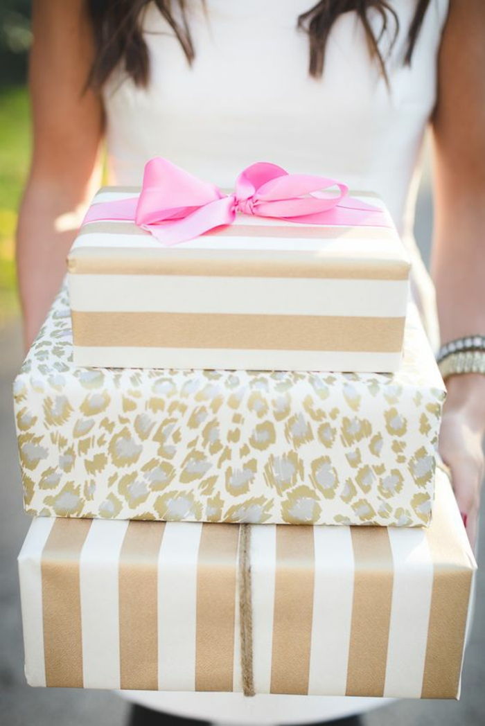 Vakkert pakke gaver - gyldne omslag med rosa bånd til bryllup