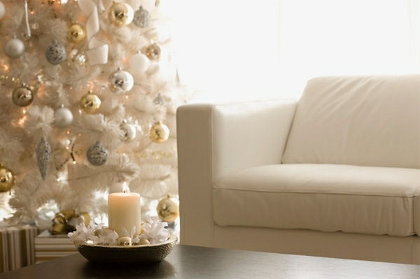 białe świąteczne dekoracje - duża choinka i elegancka sofa w białym kolorze
