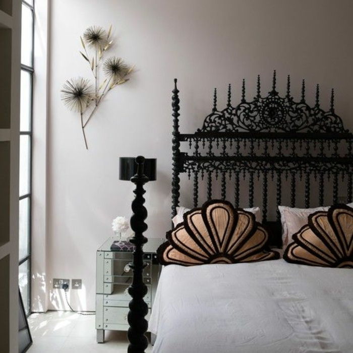 Gotsko opremljena spalnica z zakonsko posteljo v kovini z mnogimi okraski, vzglavniki vzorec, dekoracijo sten