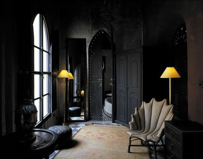 Relaxecke z gotskim foteljom, preproga v naravnih barvah, črne stene, črna komoda, dve talne svetilke