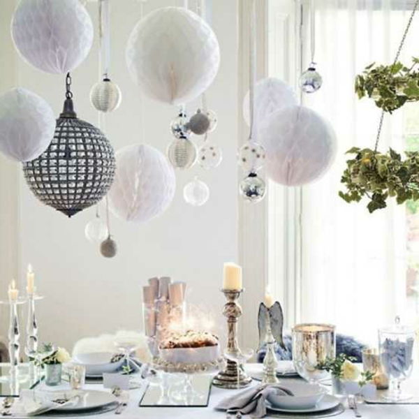 białe świąteczne dekoracje - wiszące białe kulki nad stołem