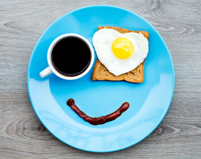Günaydın tebrik - mavi bir tabak, bir göz ve bir fincan kahve olarak kızarmış yumurta