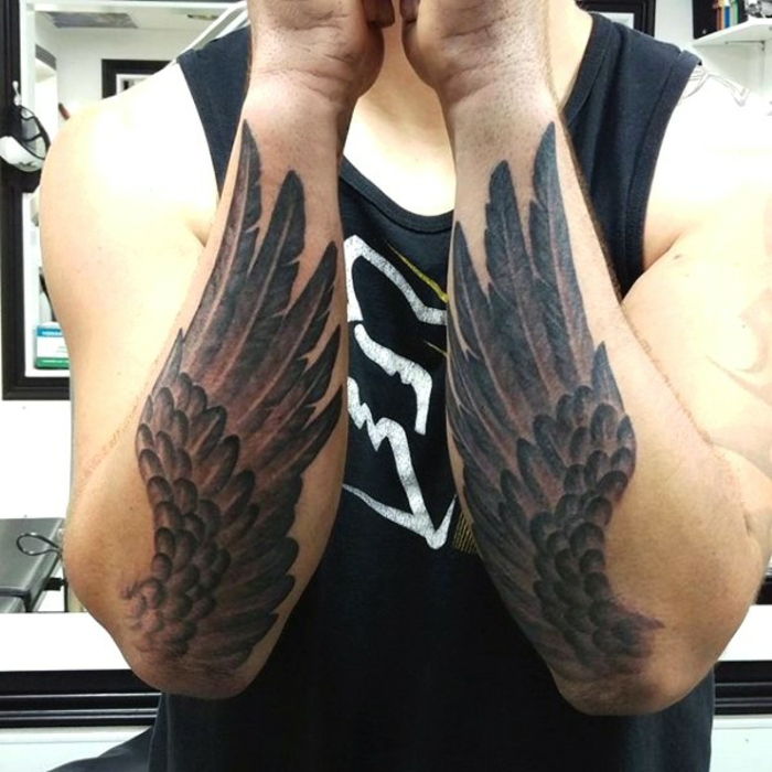 skvelý nápad pre tetované ruky - tu sú dve ruky s dvoma čiernymi anjelskými krídlami s dlhým perím