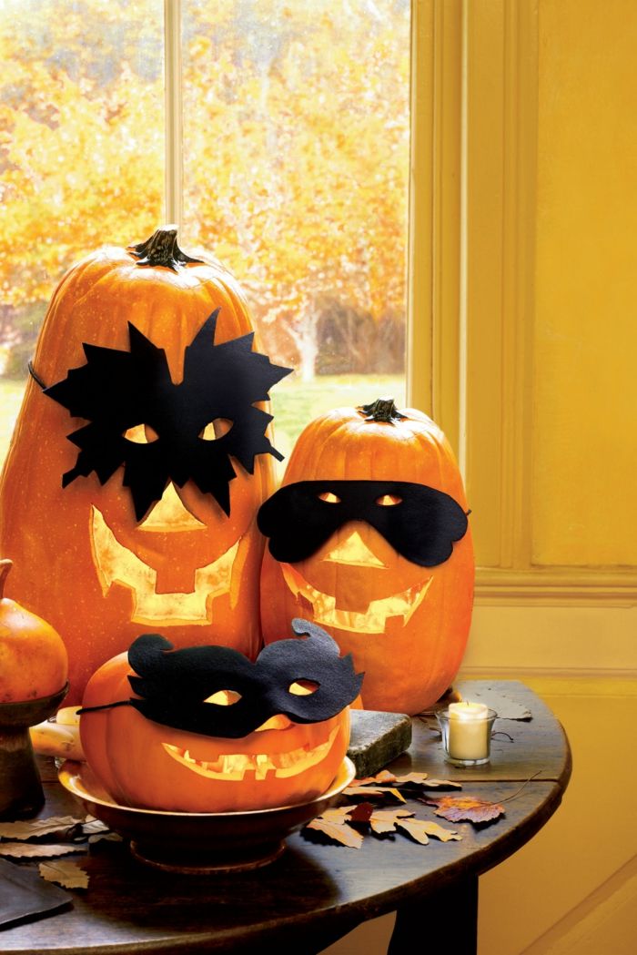 Abóboras de limpeza, abóboras assustadoras com máscaras, enfeites de mesa de Halloween, folhas de outono e velas perfumadas