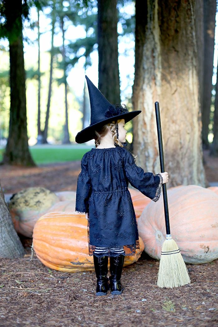 uma bruxinha fofa, traje de Halloween para meninas, abóboras gigantes, outono na floresta