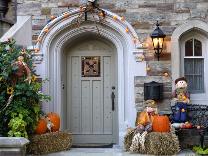 Una porta con luci fatate come zucche, bambole di paglia e zucche di Halloween