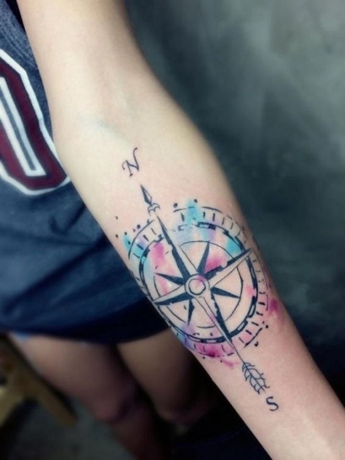 Tai yra vienas iš gražiausių spalvingų tatuiruočių su dideliu juodu kompasu - idėja kompaktinio tatuiruotė jaunos moters rankoje