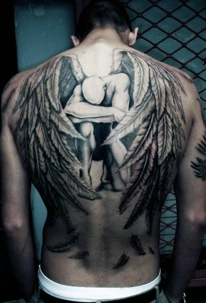 smutny, płaczący anioł o dużych białych skrzydłach z długimi piórami - kolejny pomysł na ładny tatuaż z anielskim skrzydłem, który mężczyźni naprawdę mogą lubić