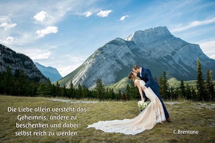 Ora ti mostriamo una foto con una sposa e uno sposo, montagne, foresta, alberi verdi e una giovane donna con un bellissimo abito da sposa bianco