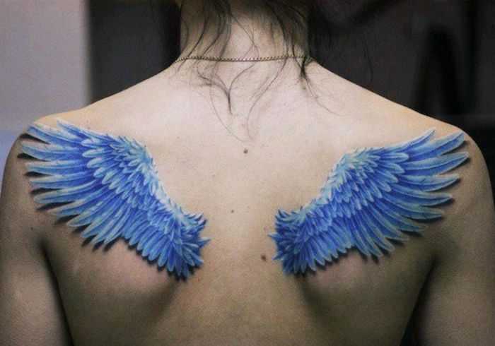 Žena s dvoma malými modrými anjelskými krídlami s modrým dlhým perím - ďalšou myšlienkou tetovacieho anjelského krídla