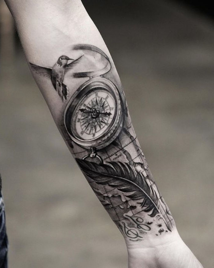 paukštis, juodas kompasas ir ilgas juodas plunksnas - kompaso tatuiruotė ant rankos idėja