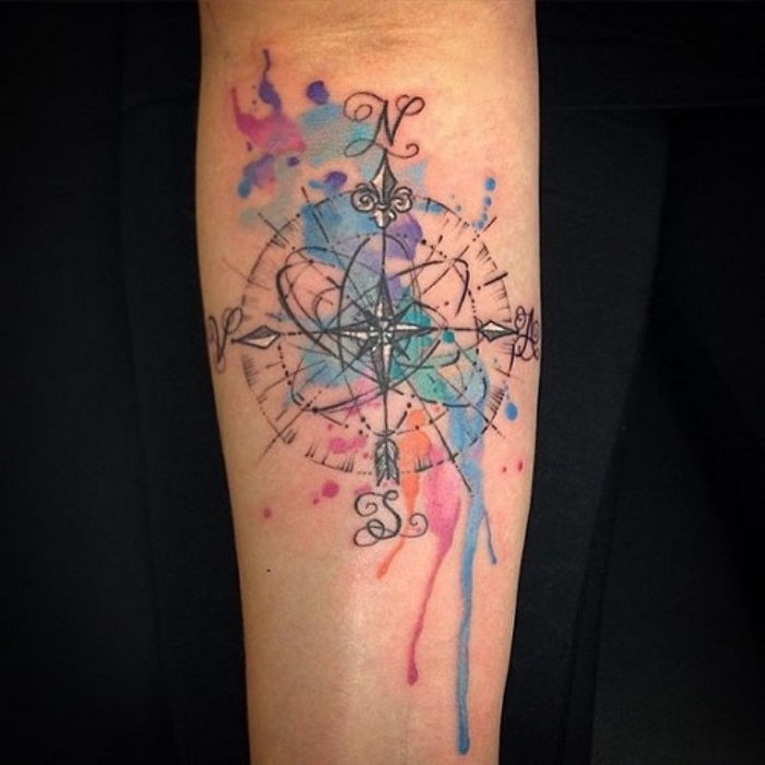 Idé för en färgstarkt stor tatuering med en stor svart kompass med svarta pilar - en tatuering på handen