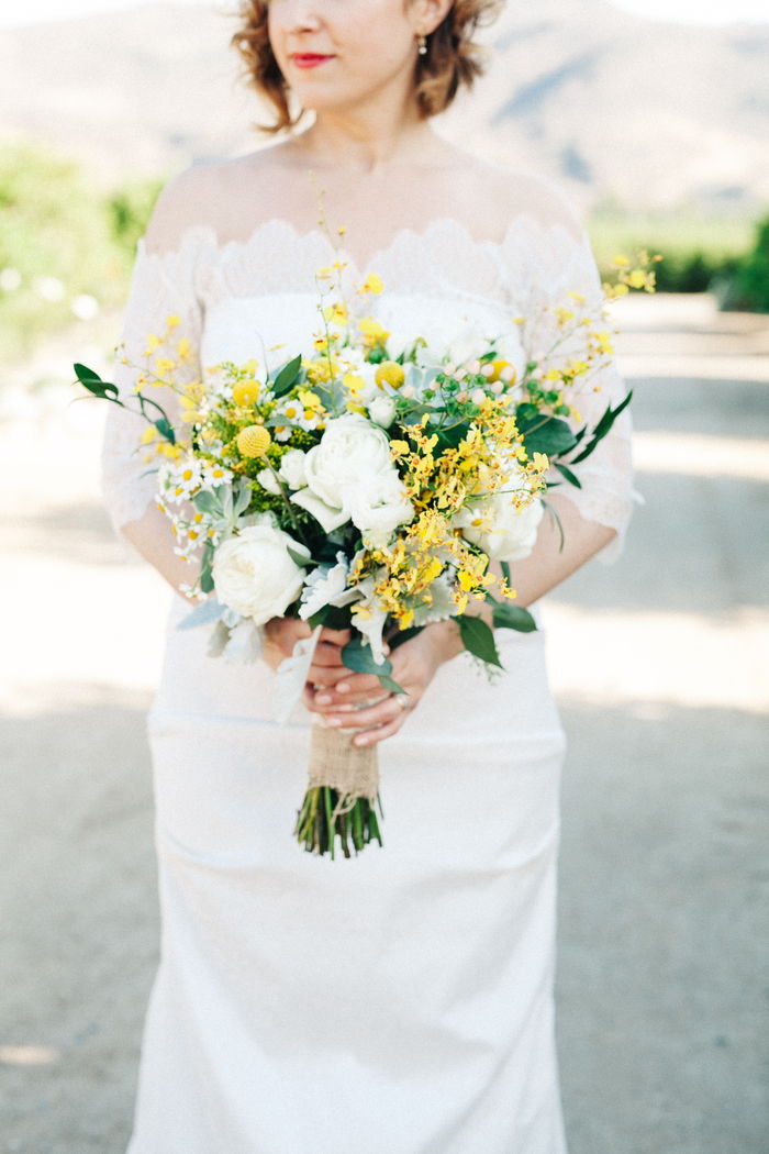 prachtige witte bruidsjurk, gele bloemen en witte rozen in vintage bruidsboeket