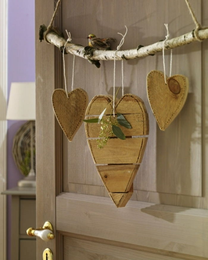 Tre dekorative dekorative biter av hjerte deco elementer hengende på dør gren for å bruke som dekorasjon