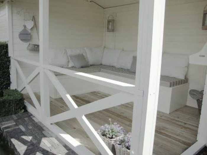 drewno-dom-z-białe malowane ganek-sitting-rogu-z poduszkami