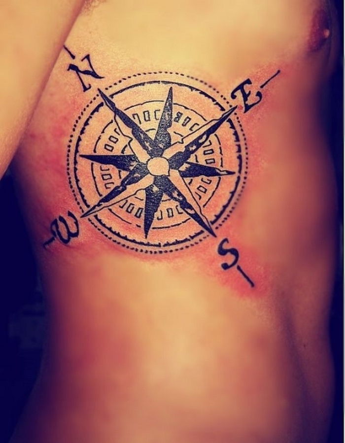 Här är en modern vacker svart tatuering med en stor kompass