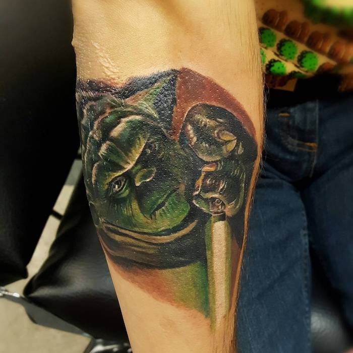 ruka so zeleným malým Jedi - jódom so zeleným svetelným mečom