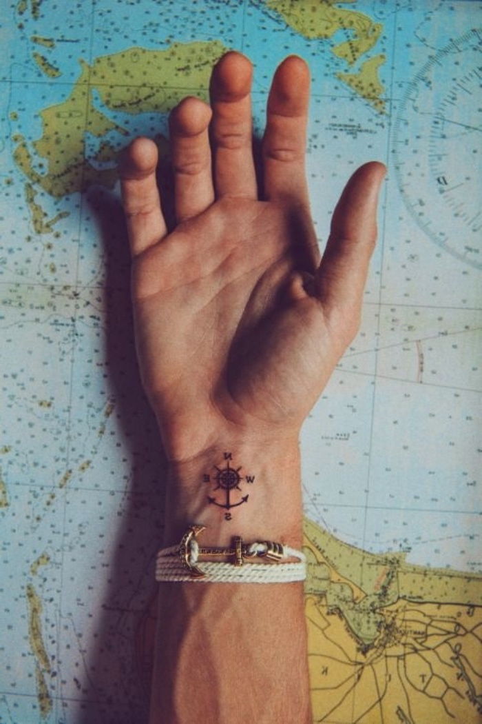 verdens kart, et svart lite anker og et svart lite kompass - ide for kompass på håndleddet