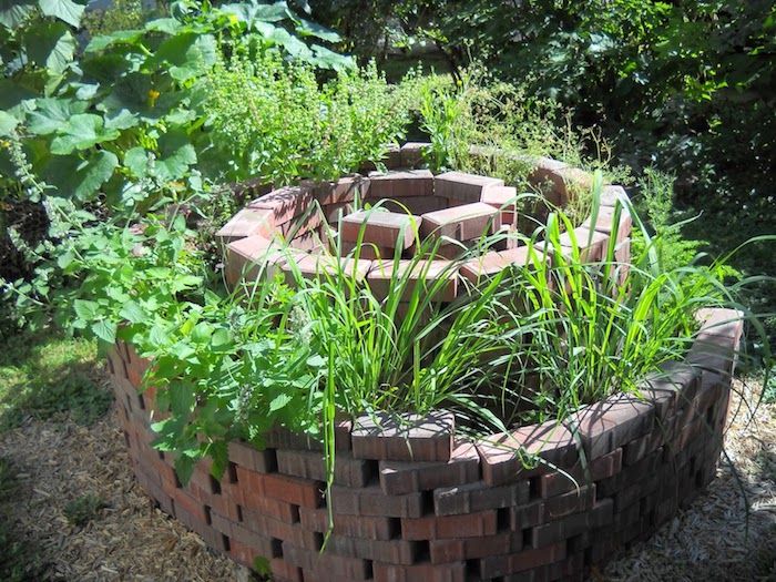 Ta en titt på denne ideen for en hage med en fin liten urtespiral med steiner og grønne planter
